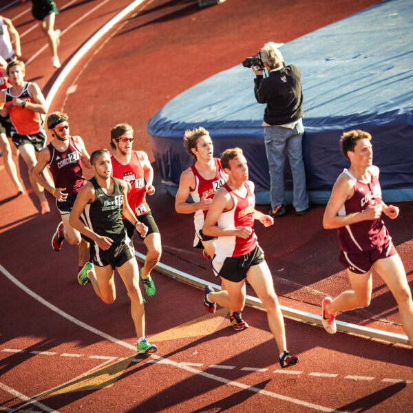 college track event with runners in afternoon sun